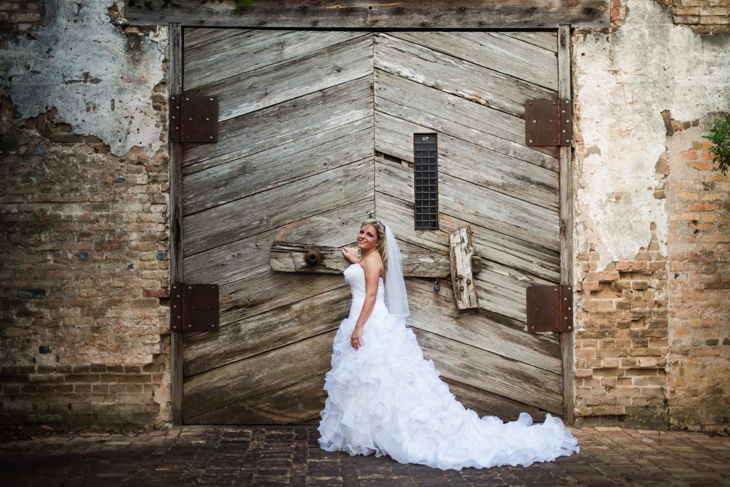 Wedding dress preservation bride in front of large barn door