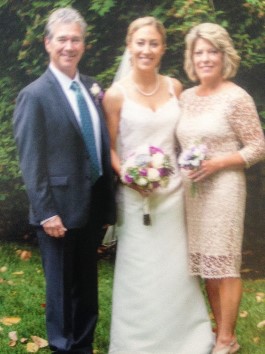 Catie with Mom and Dad at wedding. A second generation wears this wedding gown after expert transformation.