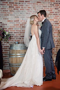 Jenni and husband enjoy wedding day kiss.  Jen's dress will need expert wedding dress cleaning after her big day.